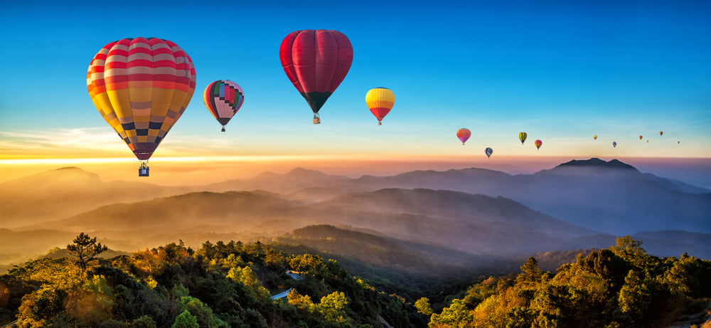 Hot Air Balloons floating over top mountains