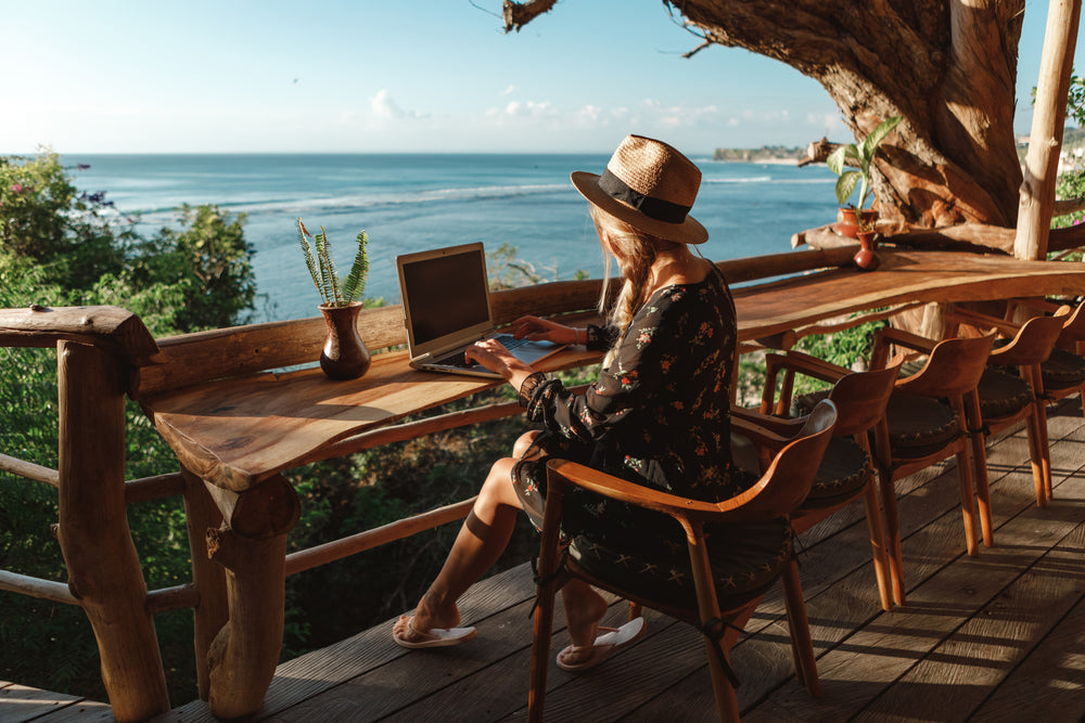 woman working on laptop overlooking the ocean