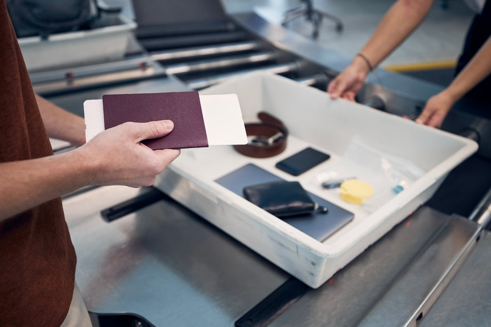 Man going through airport security putting his belongings inside a tray