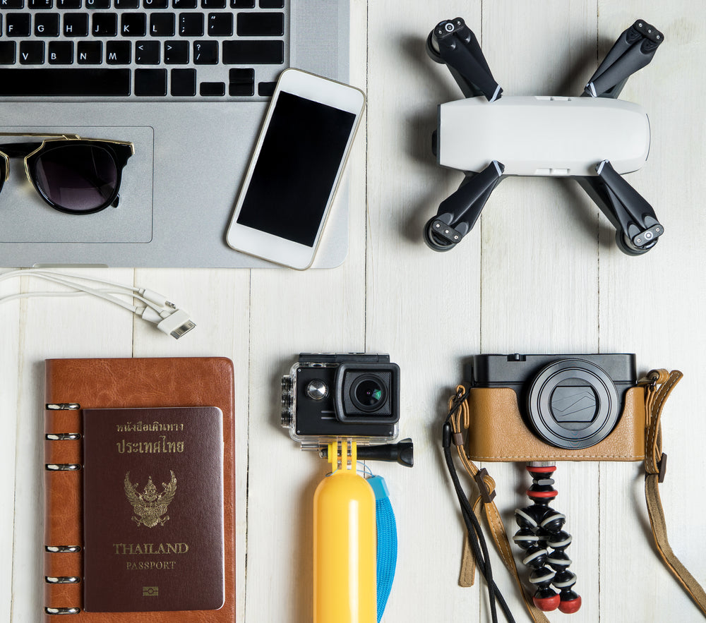 Travel gadgets. iPhone, passport, drone, selfie stick, GoPro and camera 