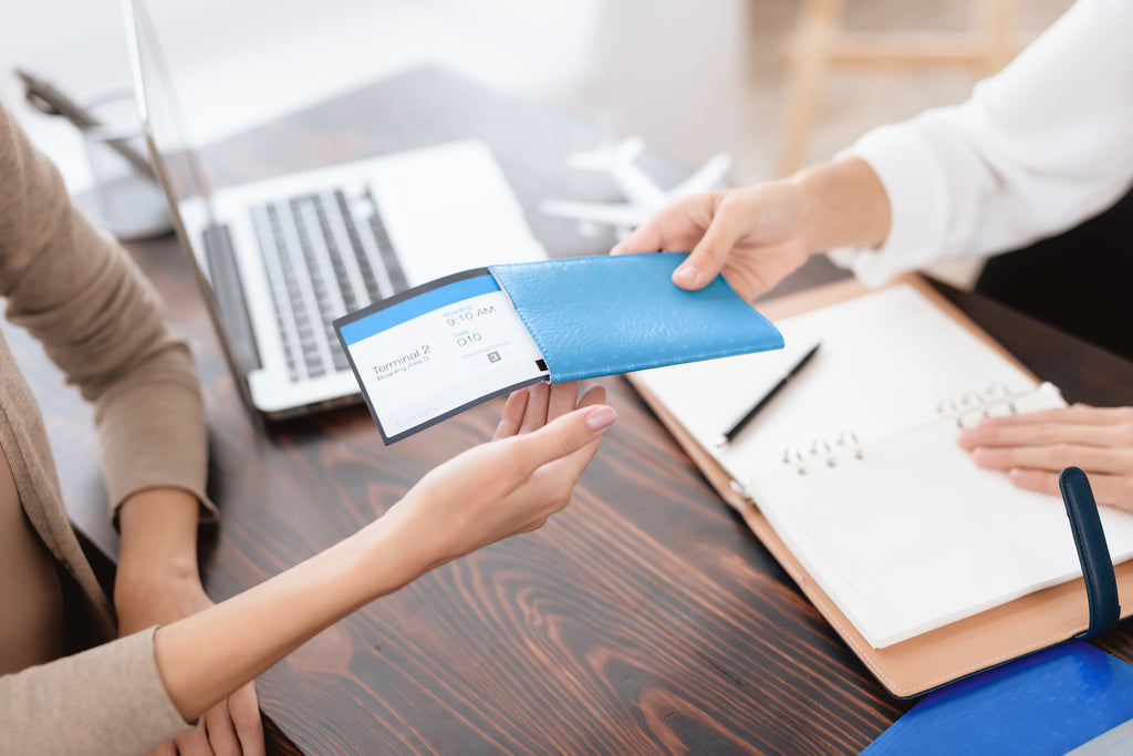 Woman accepting airline ticket from travel agent