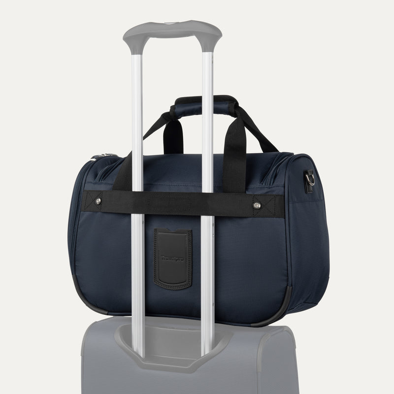 rear view of the midnight blue travelpro maxlite 5 soft tote stacked on a suitcase handle using the integrated rear attachment strap for hands-free mobility.