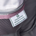 close up of the interior fabric tag on the dusty rose pink travelpro maxlite 5 soft tote showing a green recycling symbol and text stating lining made from 100 percent post consumer recycled plastic bottles.