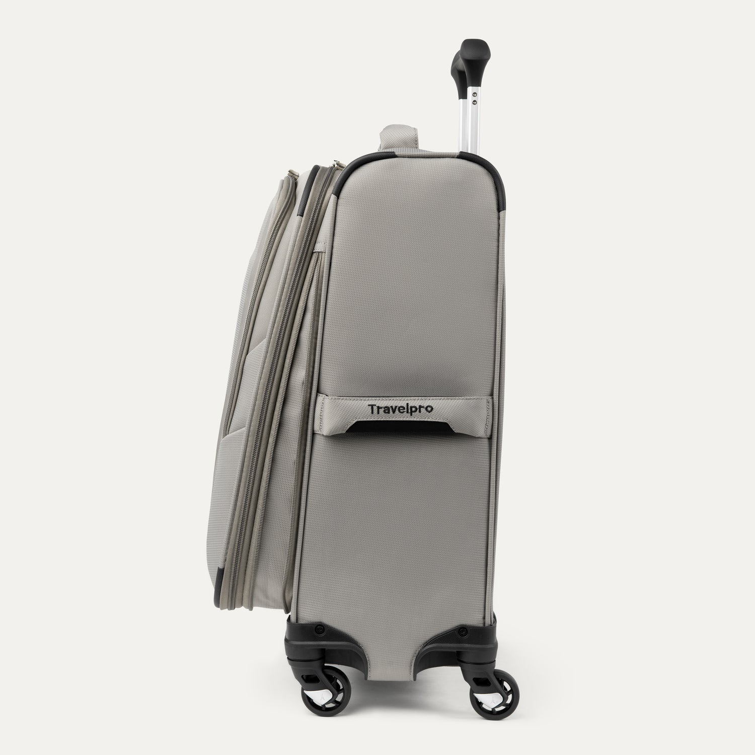 Side view of Maxlite® 5 Carry-On Spinner in gray, showcasing the side carry handle with Travelpro® branding, dual spinner wheels, and the lightweight profile.
