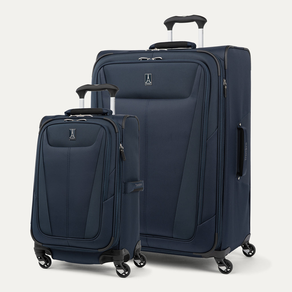 Two navy blue suitcases with wheels on a light gray background