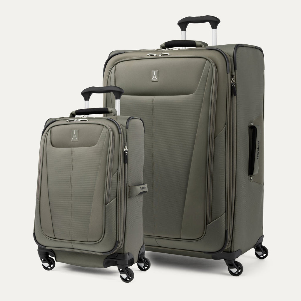 Two green suitcases of different sizes on a white background