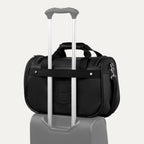 Black  tote with a black rear strap over suitcase handle on a white background

