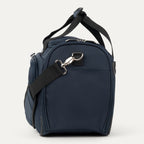 Side view o navy blue bag with black strap on a white background