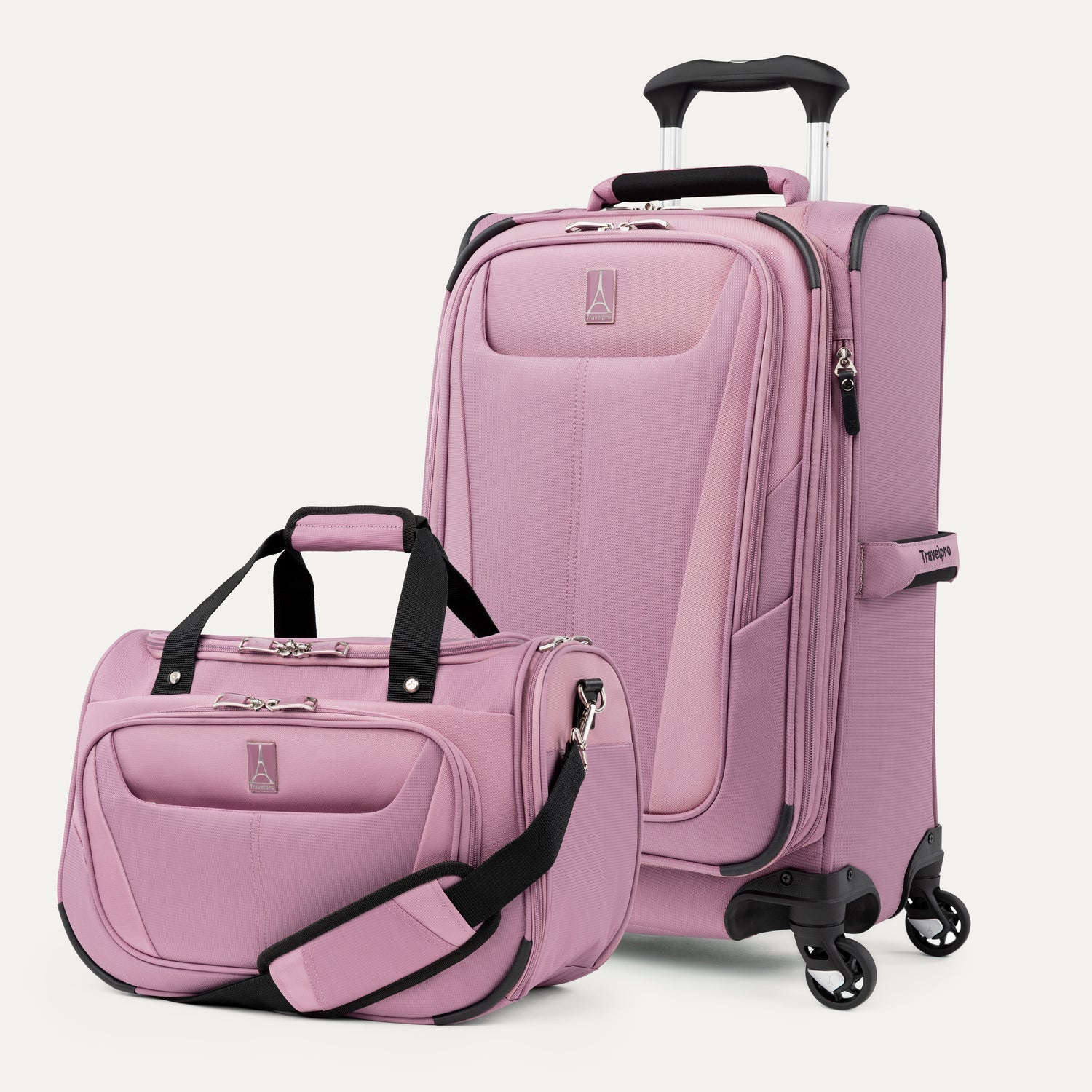 Pink suitcase and matching tote with black handles and zippers on a white background