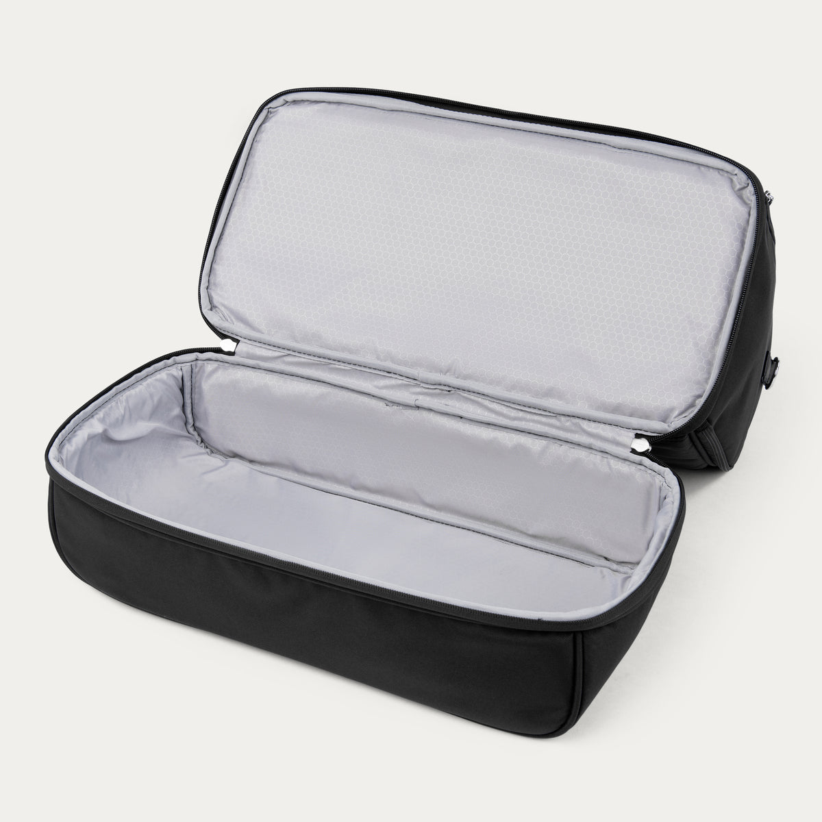 interior view of the open drop bottom compartment on the black travelpro maxlite 5 weekender showing the spacious storage area with light gray lining.