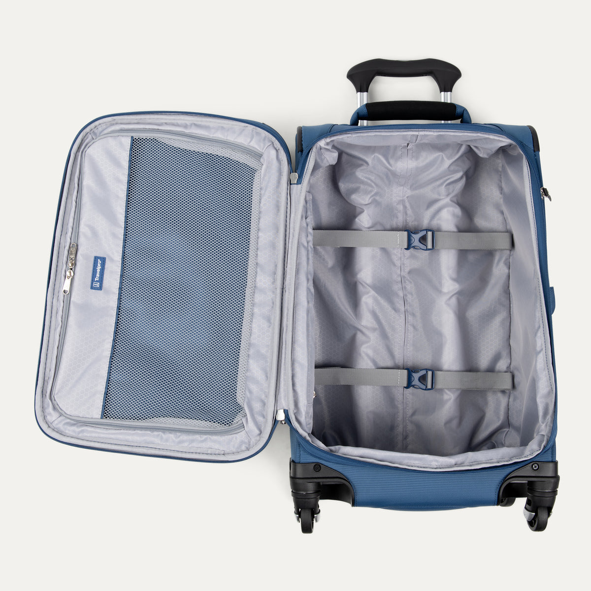 Interior view of the open Ensign Blue Maxlite 5 Compact Carry-On Spinner, showing the gray lining with adjustable compression straps and a large mesh lid pocket against a light gray background.