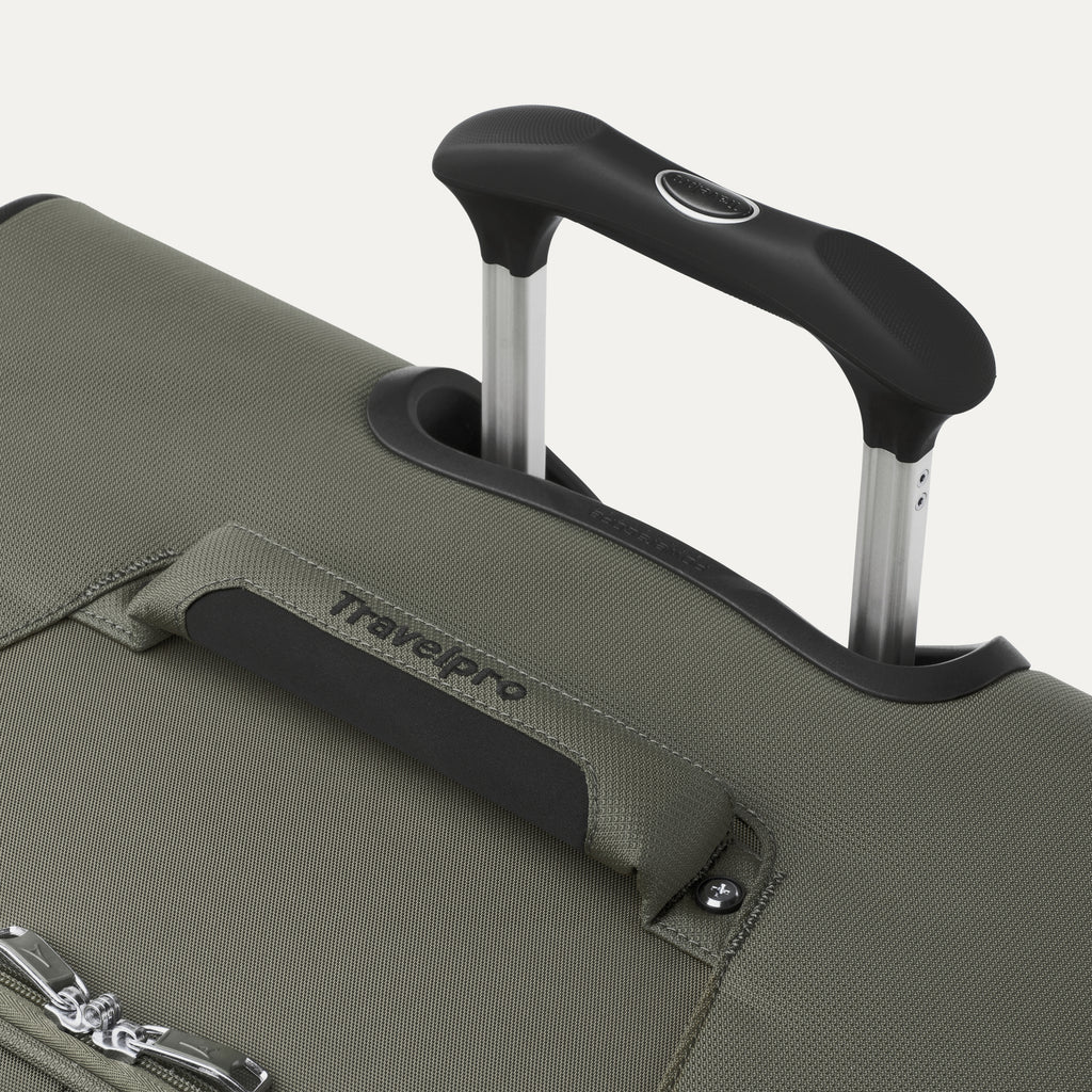 close up of the slate green travelpro maxlite 5 large check-in spinner showing the ergonomic contour grip on the powerscope lite handle and the cushioned top carry handle with travelpro branding.