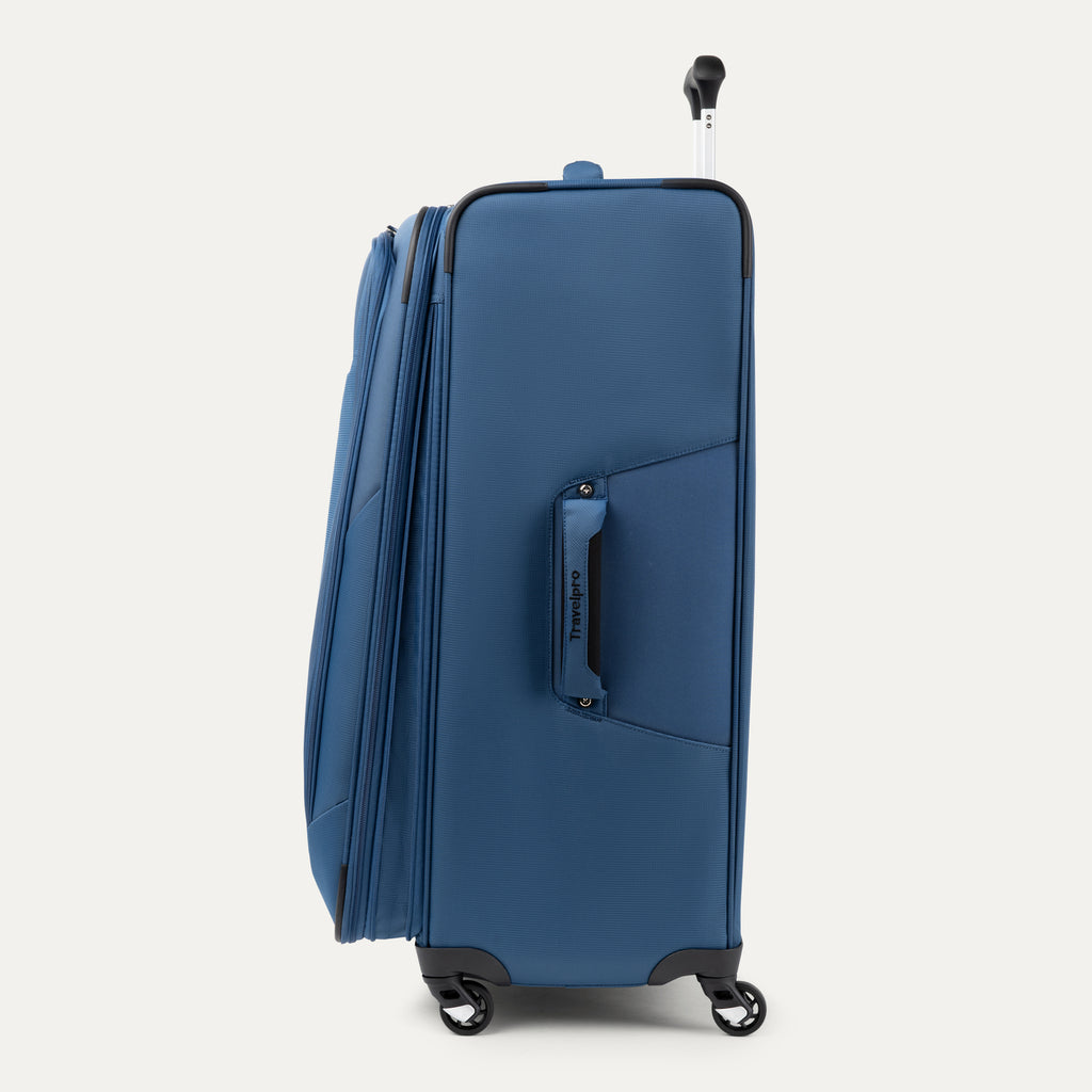 side profile view of the ensign blue travelpro maxlite 5 large check-in spinner showing the side carry handle, expansion zipper, and slim profile.