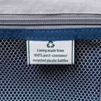 close up of the interior fabric tag on the ensign blue travelpro maxlite 5 large check-in spinner showing a green recycling symbol and text stating lining made from 100 percent post consumer recycled plastic bottles.