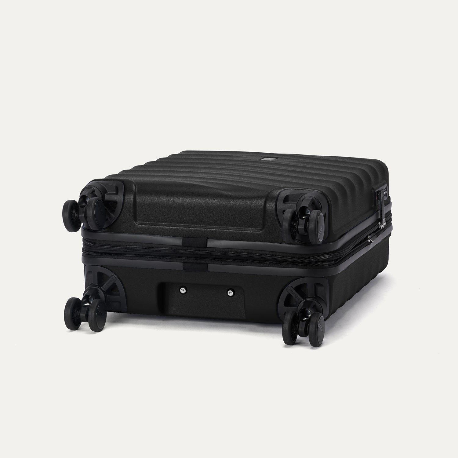 Bottom view of Travelpro Maxlite Air V2 Compact Carry-On Spinner in Black, showing durable wheels and textured shell