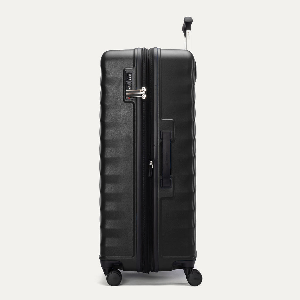Side view of Travelpro Maxlite Air V2 Check-In Spinner in Black, showing expandable zipper, Low-Profile Side Carry Handle, and extended PowerScope Lite Handle.