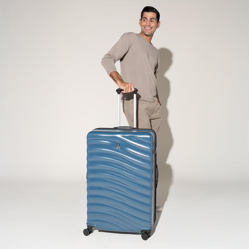 Person standing beside the Travelpro Maxlite Air Large Check-In Hardside Spinner in Teal, ready for effortless travel.
