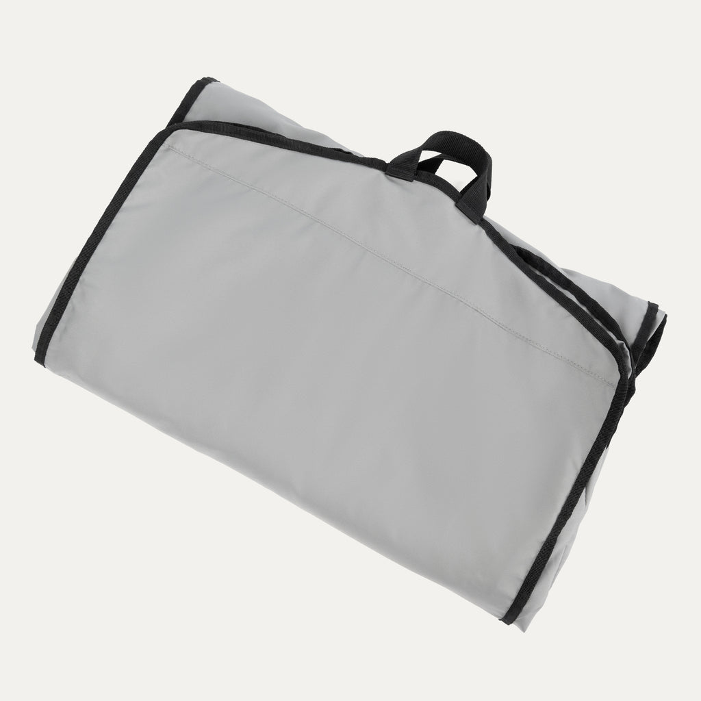 Travelpro® Essentials™ Drop-in Garment Sleeve shown folded and secured with black edge trim and a top carrying handle for easy transport.