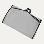 Travelpro® Essentials™ Drop-in Garment Sleeve shown folded and secured with black edge trim and a top carrying handle for easy transport.