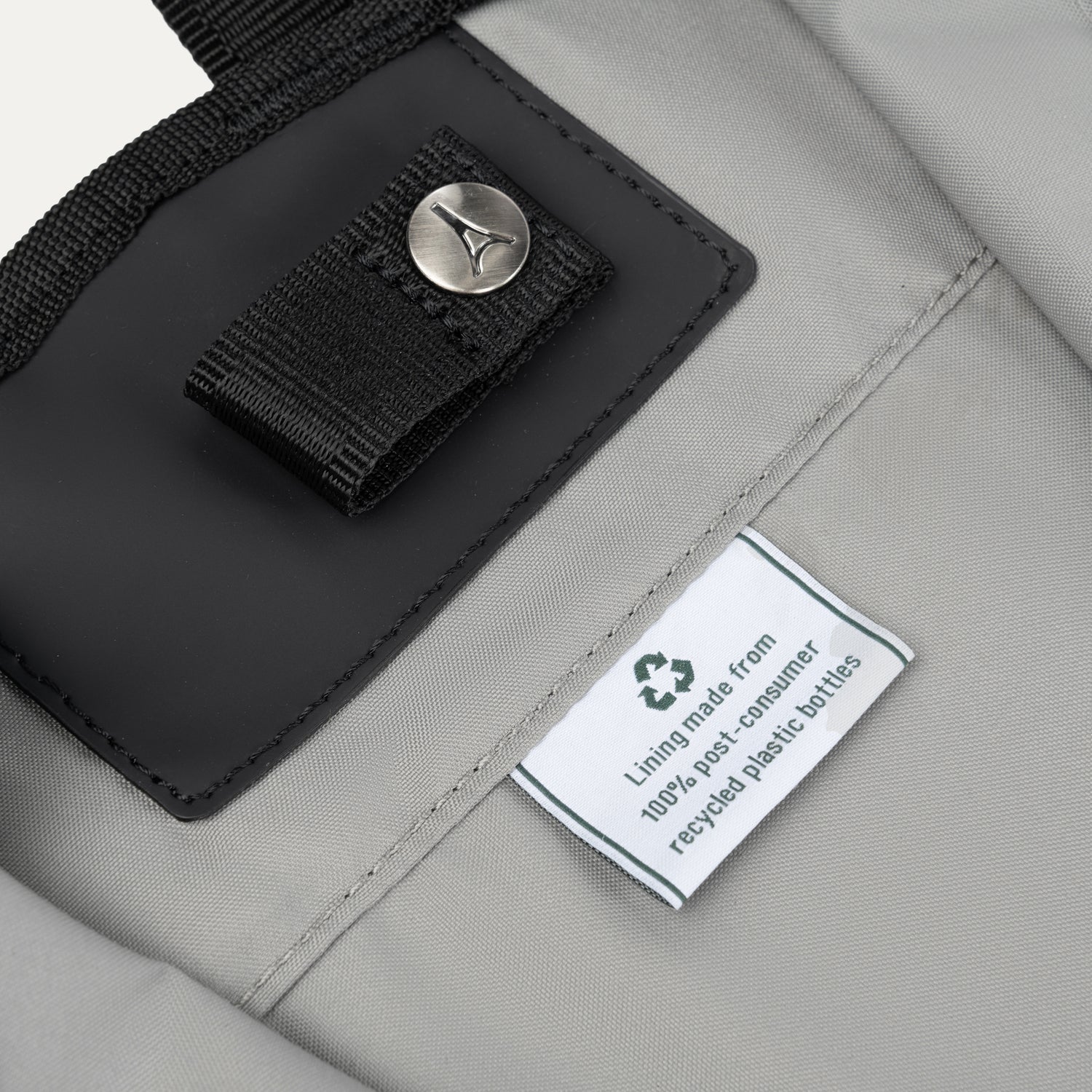 Close-up of the Travelpro® Essentials™ bag interior tag, showing the eco-friendly lining made from 100% post-consumer recycled plastic bottles