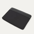 Travelpro® Essentials™ 13"/14" Laptop Sleeve in Black, shown angled to highlight the sleek padded body and reinforced leather-accented top edge embossed with the Travelpro® logo