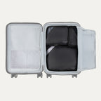 Top view of Travelpro Essentials 3 Pack Packing Cube Set in BLACK, efficiently arranged inside an open hardside carry-on.