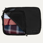 Large Travelpro packing cube in black with mesh panel, partially unzipped to reveal rolled clothing inside.
