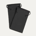 Pair of Travelpro® black drawstring shoe bags, shown overlapping with logo patch visible on the bottom corner.
