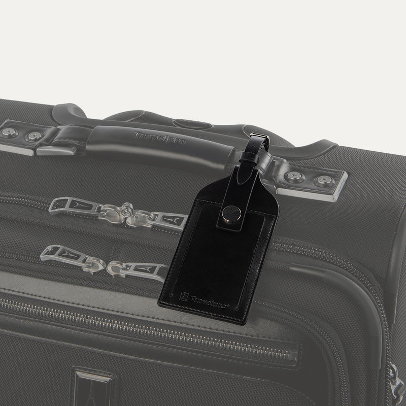 Travelpro Essentials Leather Luggage Tag in Black, attached to suitcase handle with secure buckle strap.
