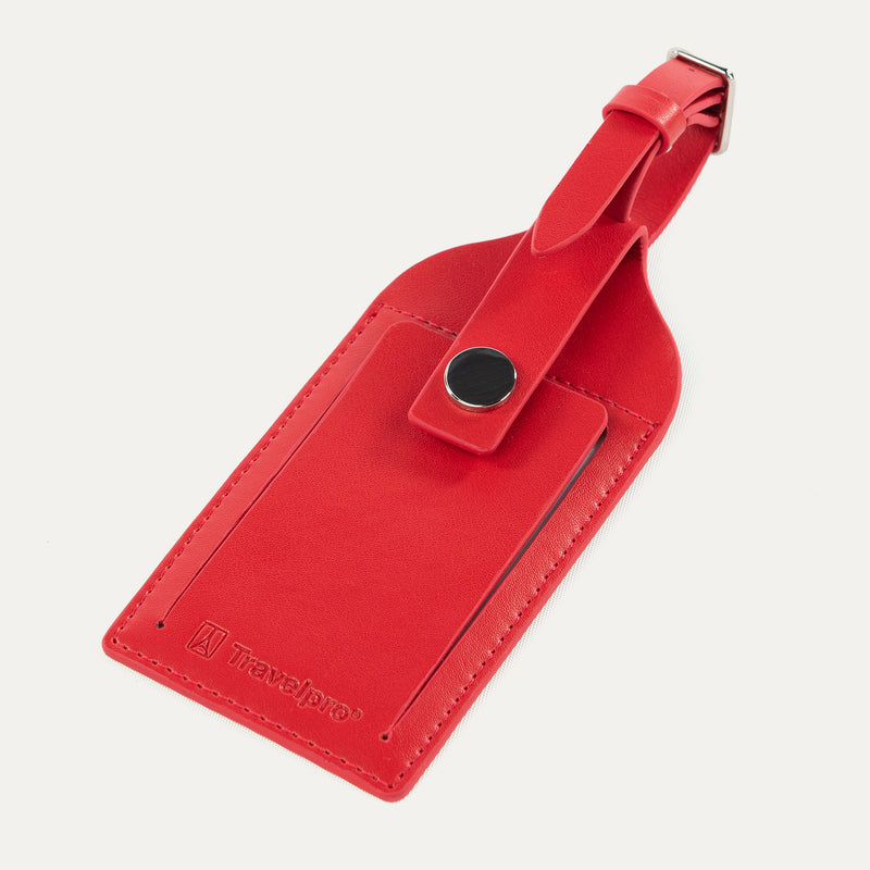Travelpro Essentials Leather Luggage Tag in Red, secured with a buckle strap and protective flap closure.
