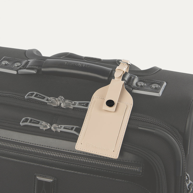 Travelpro Essentials Leather Luggage Tag in Khaki, attached to suitcase handle with secure buckle strap.
