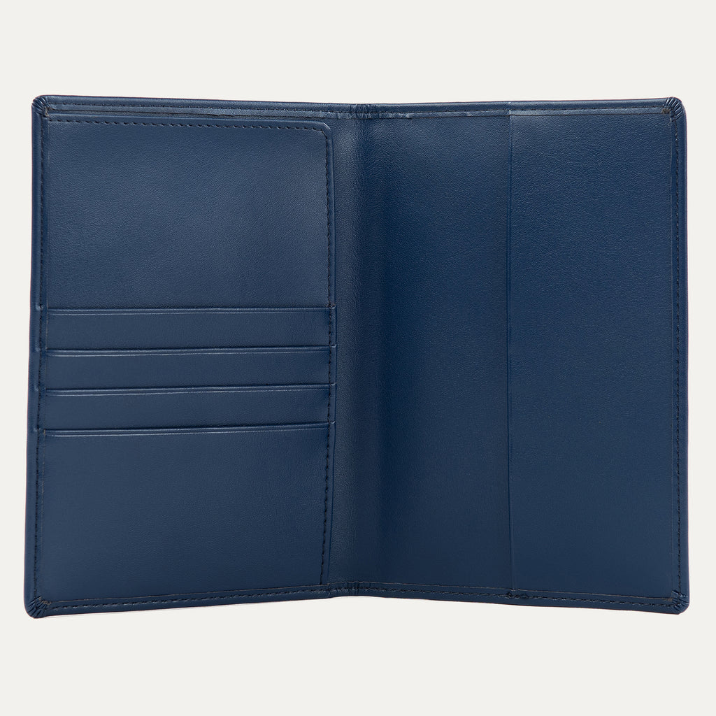 Interior view of a navy blue Travelpro passport cover, featuring multiple card slots on the left and a large pocket on the right for securely holding a passport.