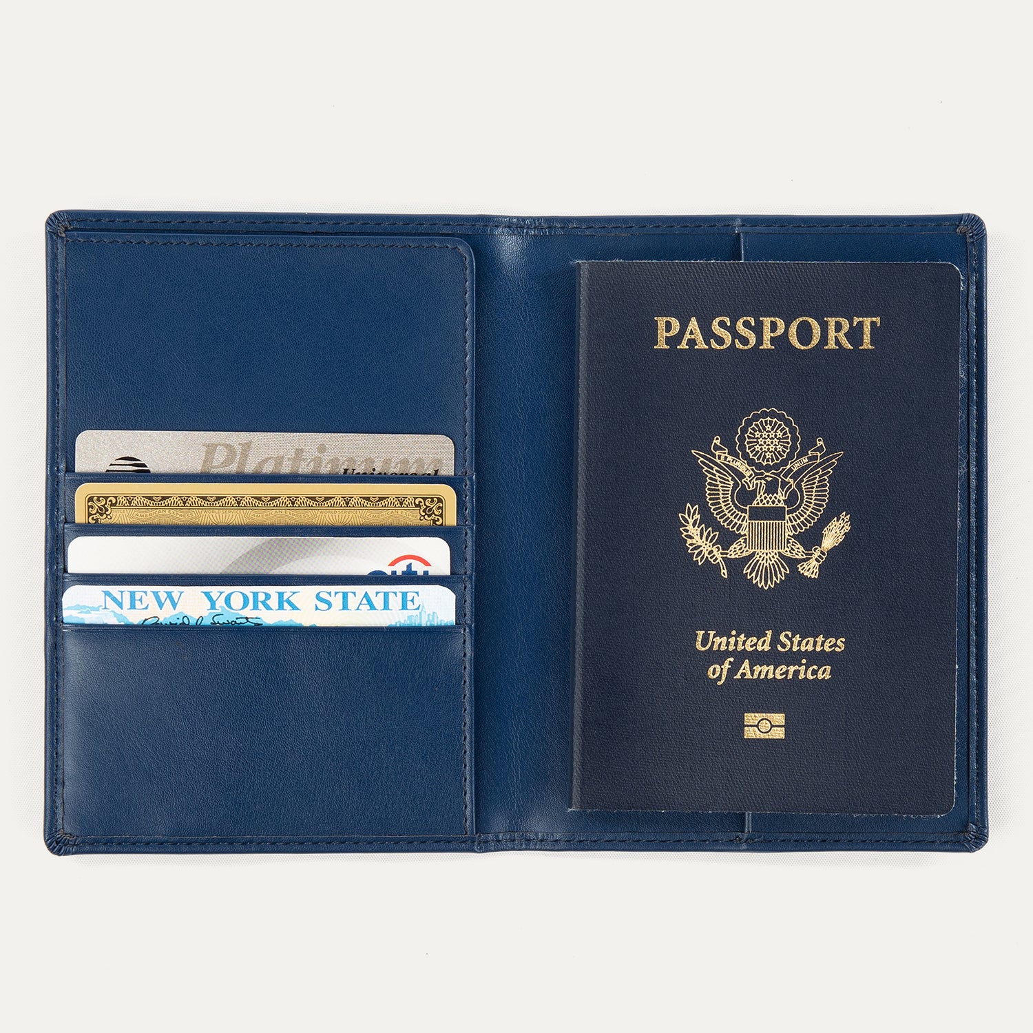 Open view of a navy blue Travelpro passport cover, showing a passport on the right side and card slots on the left holding credit cards and an ID.