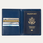 Open view of a navy blue Travelpro passport cover, showing a passport on the right side and card slots on the left holding credit cards and an ID.