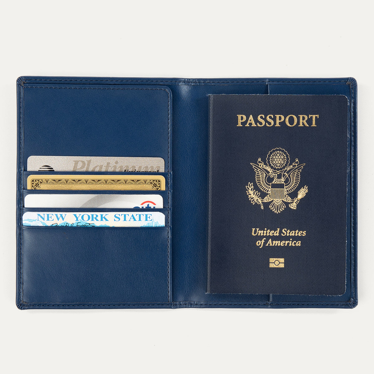 Open view of a navy blue Travelpro passport cover, showing a passport on the right side and card slots on the left holding credit cards and an ID.