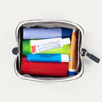 Open Travelpro MaxAccess Cubes Small Organizer in navy with white trim, shown from the top view packed with toiletries