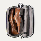 Travelpro MaxAccess Cubes™ Large Shoe Organizer in black, unzipped and open, holding a pair of brown leather dress shoes 