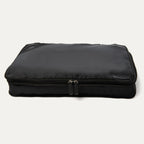 A black Travelpro Essentials XL expandable/compressible packing cube with a zipper.