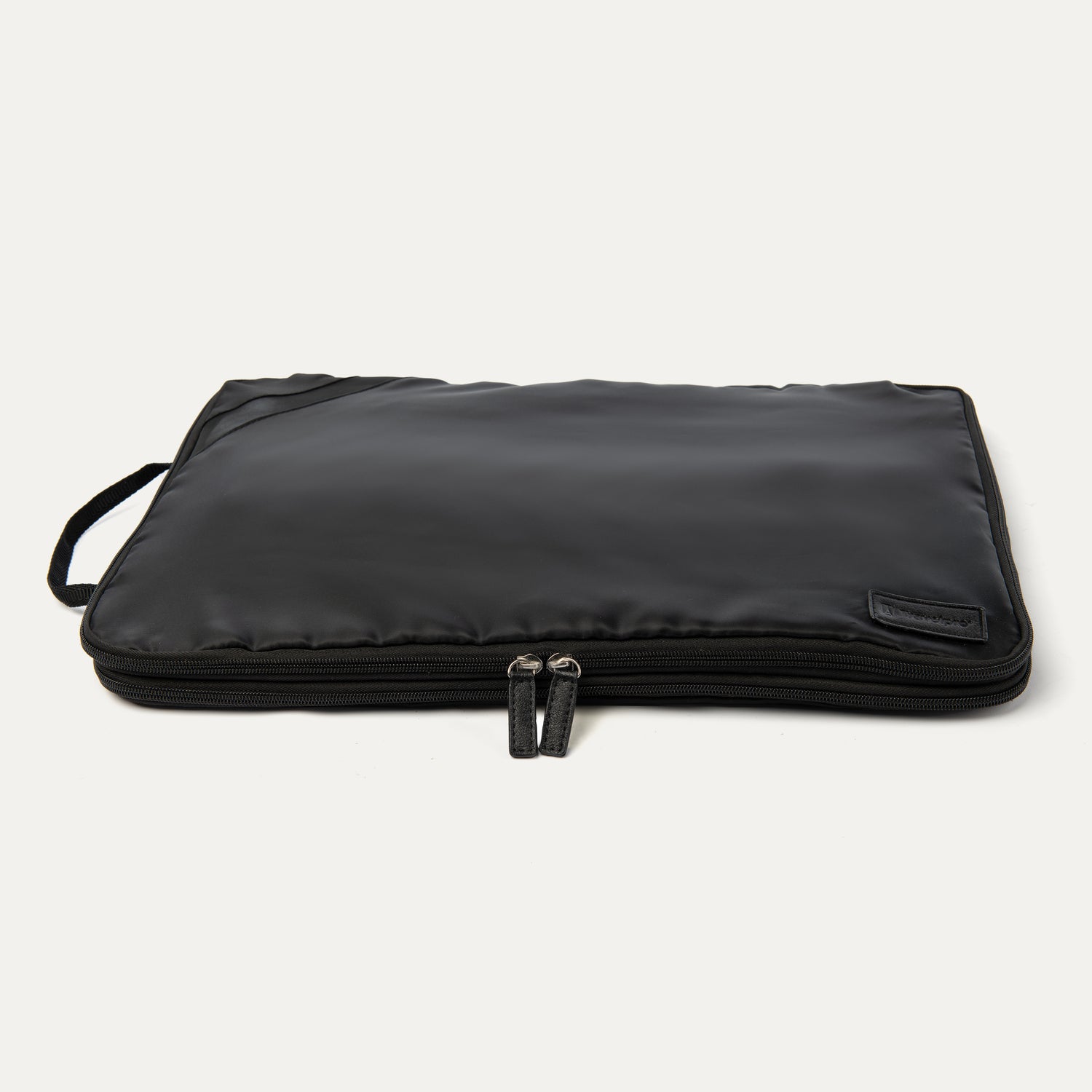 Extra-large Travelpro packing cube in black with a side handle and dual zipper closure, shown compressed.
