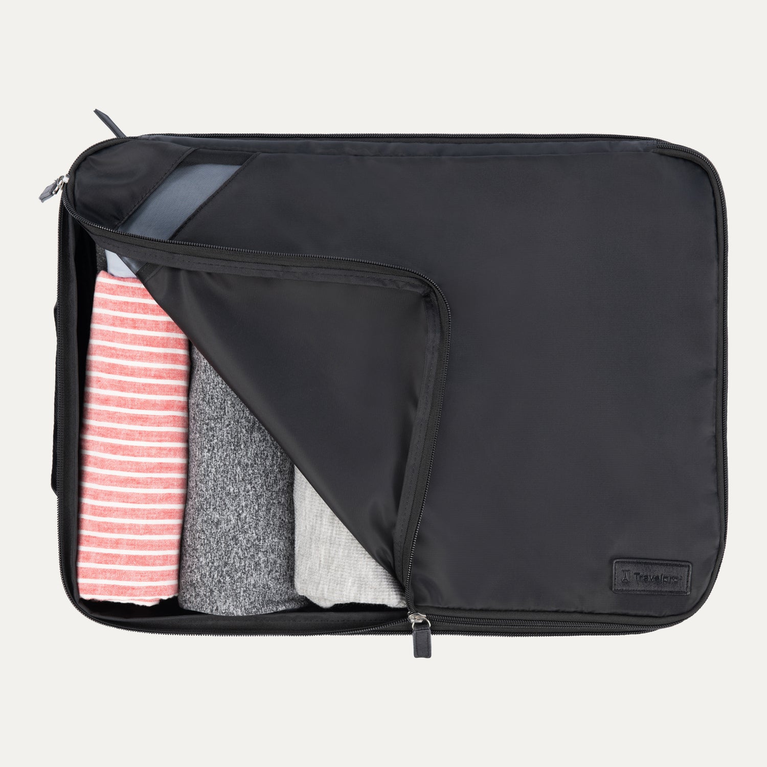 Extra-large Travelpro packing cube in black with mesh panel, partially unzipped to reveal rolled clothing inside.
