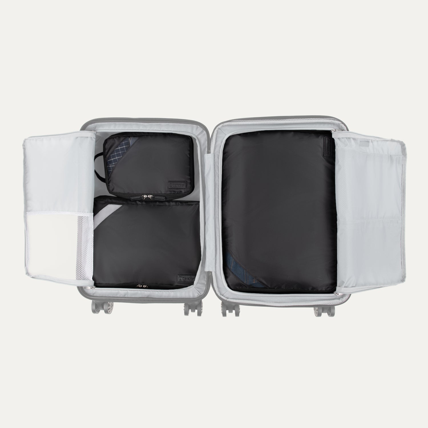 Top view of Travelpro Essentials 3 Pack Expandable/Compressible Packing Cube Set (M/L/XL) in BLACK, with all three cubes packed inside suitcase.
