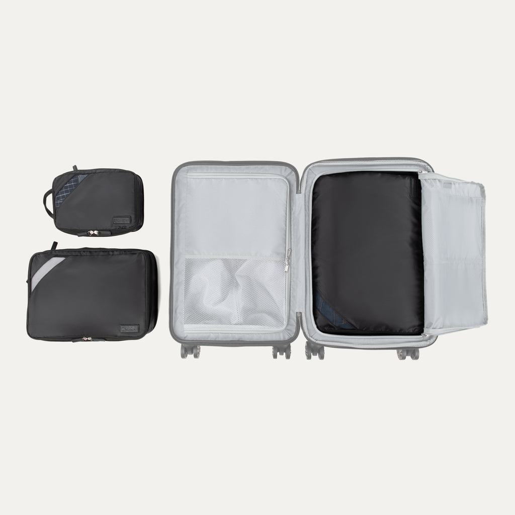 Top view of Travelpro Essentials 3 Pack Expandable/Compressible Packing Cube Set (M/L/XL) in BLACK, with XL packed in suitcase and M and L outside.
