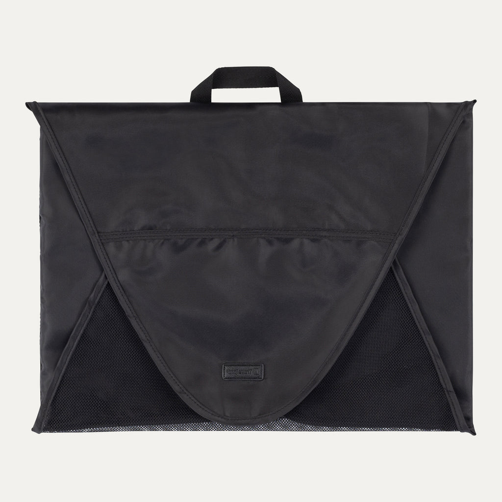 A black Travelpro Essentials Garment Packing Folder, designed to organize and protect clothing during travel.