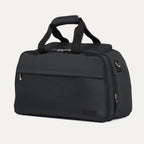 Travelpro® Essentials™ 2-in-1 Travel Tote & Cooler in Black, shown at a front angle to highlight its structured design, dual top handles, front zippered pocket, and side D-rings for attaching the adjustable shoulder strap.