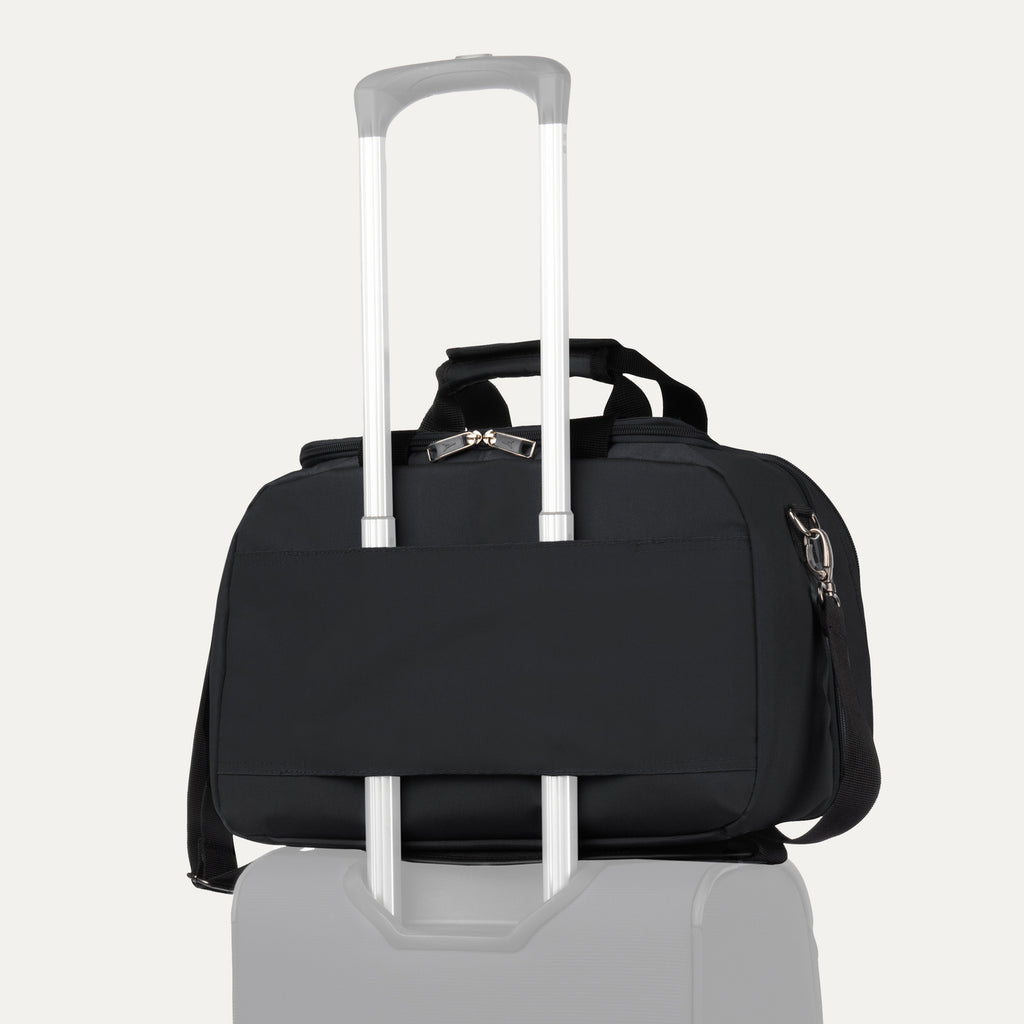Travelpro® Essentials™ 2-in-1 Travel Tote & Cooler in Black, shown securely attached to a rolling suitcase handle using its rear strap, demonstrating its convenient stacking ability