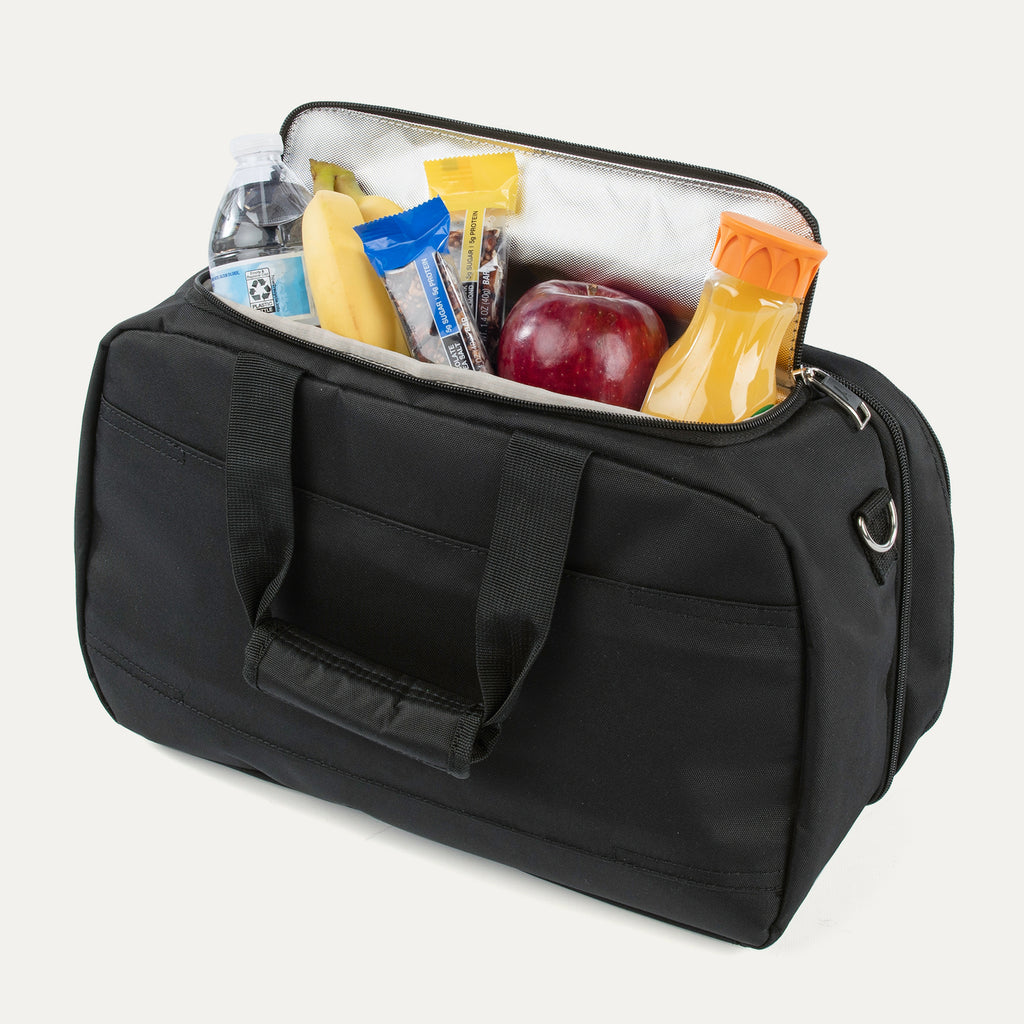 Travelpro® Essentials™ 2-in-1 Travel Tote & Cooler in Black, shown with the insulated cooler compartment open and stocked with snacks, fruit, a water bottle, and juice, demonstrating its functionality