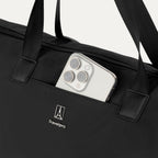 Close-up detail view of the Travelpro Essentials SparePack Foldable Tote 2.0 in Black, highlighting the QuickSlip front pocket with a smartphone tucked inside for convenient, quick access to essentials.