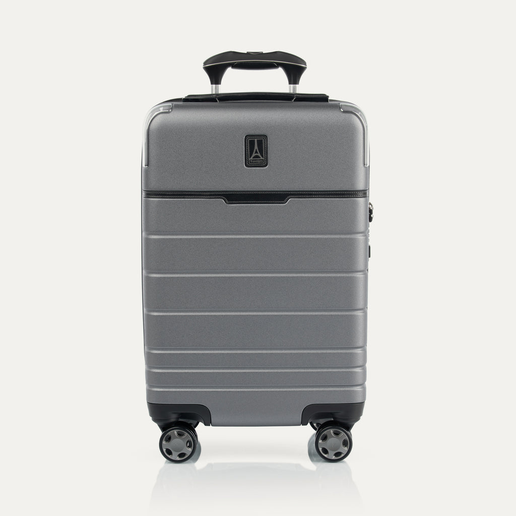 Front view of T+L Carry-On Spinner in Whistler Grey, featuring a matte hard shell, tonal trim, horizontal grooves, and dual spinner wheels.
