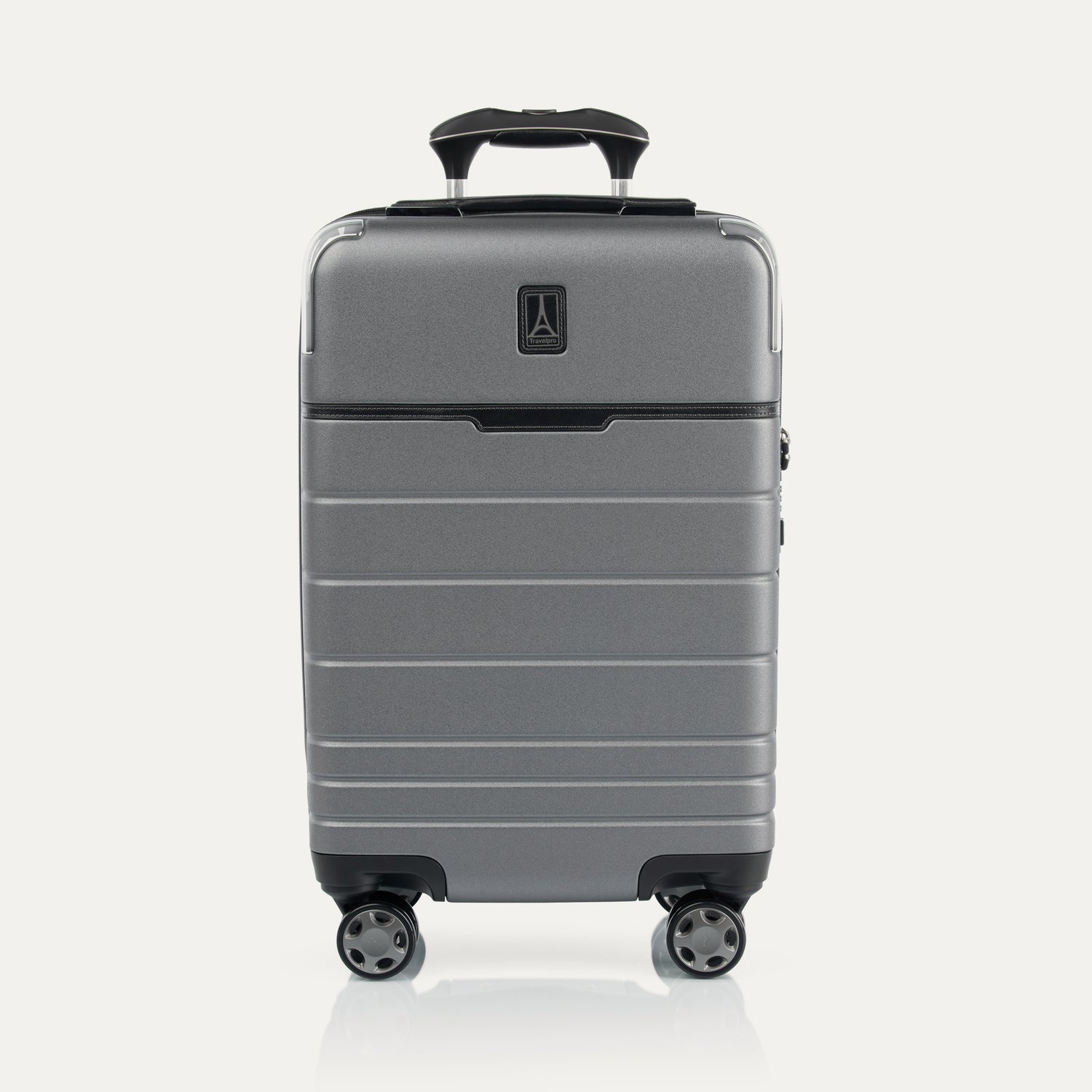 Front view of T+L Carry-On Spinner in Whistler Grey, featuring a matte hard shell, tonal trim, horizontal grooves, and dual spinner wheels.
