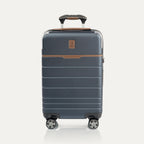 Front view of T+L Carry-On Spinner in Monaco Blue, featuring a matte hard shell, brown contrast trim, horizontal grooves, and dual spinner wheels.
